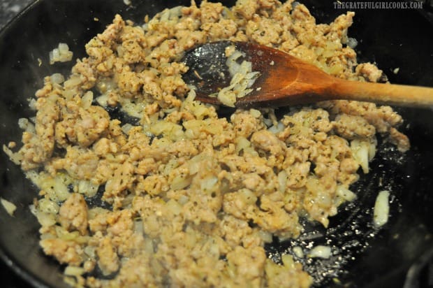 Browned Italian sausage and onion in cast iron skillet