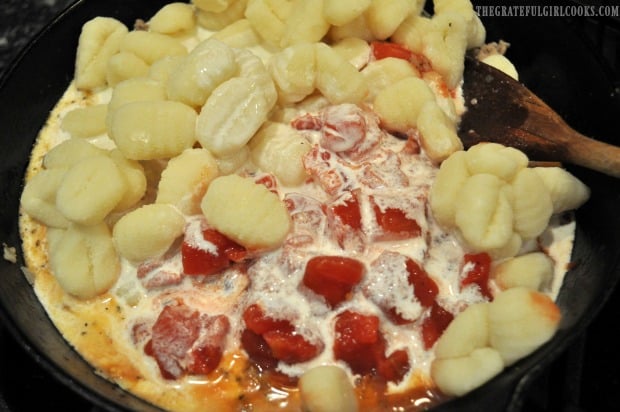 Cream and diced tomatoes added to skillet with gnocchi