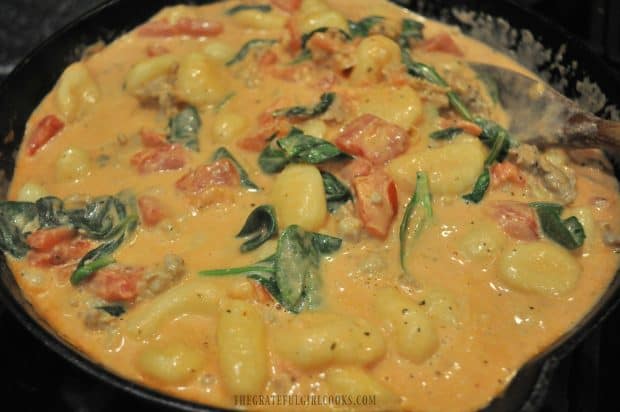 Spinach wilted into cast iron skillet with potato gnocchi