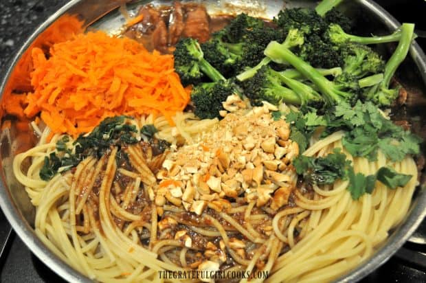 Noodles, hoisin pork, carrots and broccoli in skillet