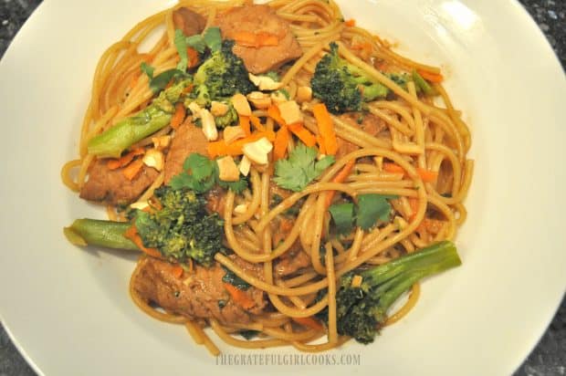 Hoisin pork, noodles and broccoli served in white bowl 