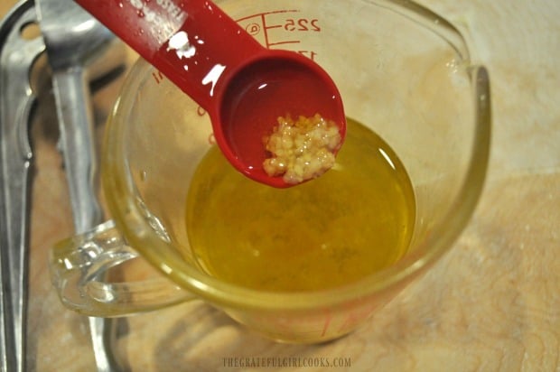Olive oil and minced garlic for bread, in measuring cup