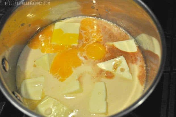 Butter, evaporated milk, eggs, cooking in pan for homemade German chocolate cake frosting