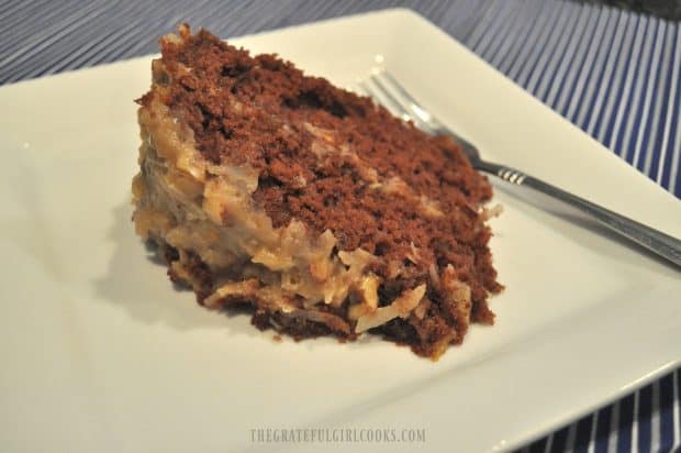 Slice of German chocolate cake served on white plate with fork