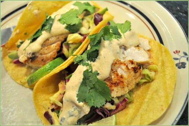 Grilled fish in tortilla with Baja sauce, slaw and cilantro, on plate