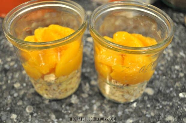 Peaches are added to oats in glass jars