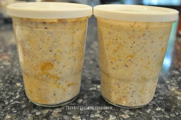 Two jars of peach overnight oats, ready to refrigerate