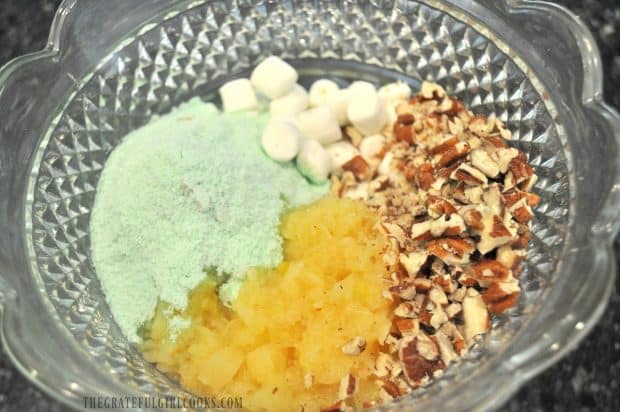 Pineapple, pecans, mini marshmallows and pistachio pudding mix in bowl