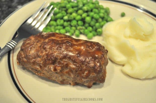 Easy Stuffed Beef Roll on plate, served with mashed potatoes and peas