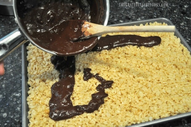 Chocolate peanut butter frosting poured over krispy treats