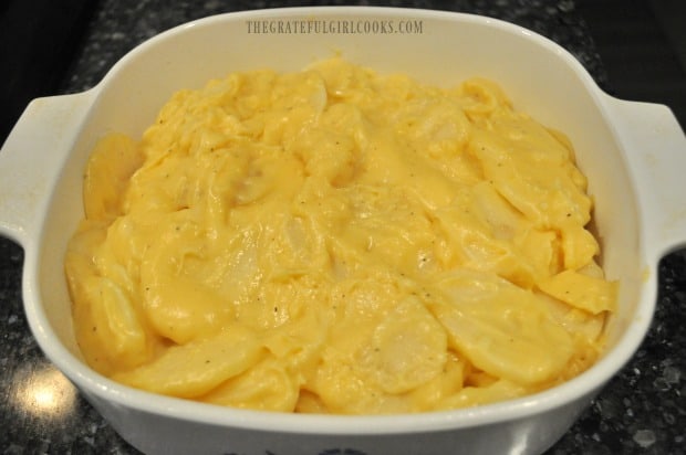 Potatoes and cheese sauce layered into baking dish