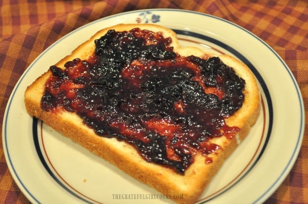 Toast with blackberry jam on a plate. 