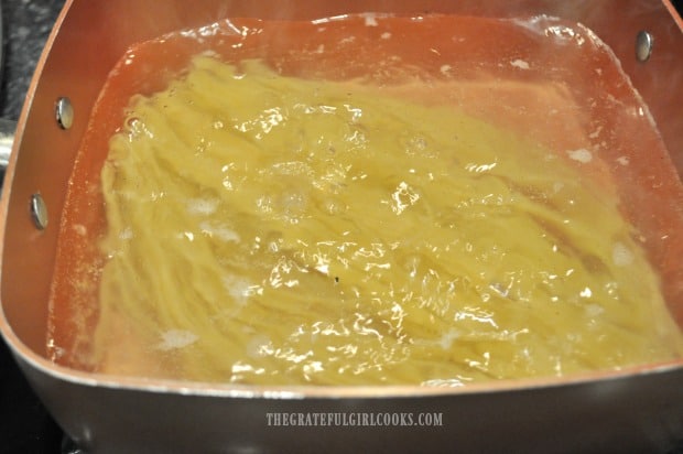 Fettucine noodles cooking in pan