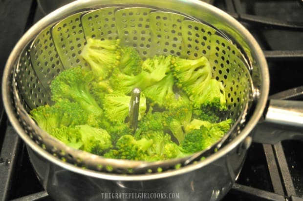 Broccoli florets are steamed before adding to alfredo sauce