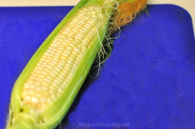 Cleaning corn silk and husk off corn in order to grill