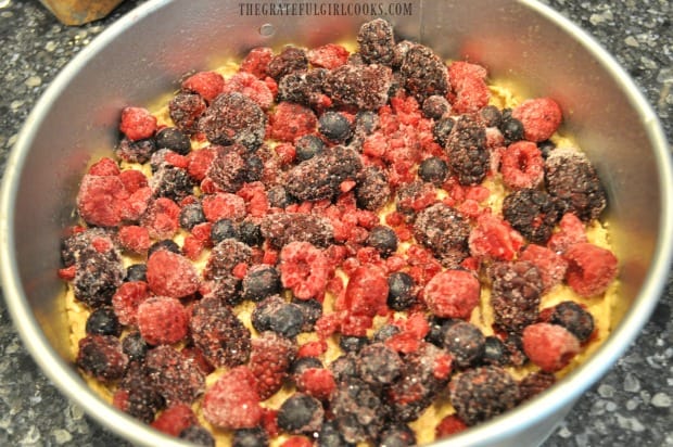 Frozen berries are placed on top of the coffeecake batter in pan.