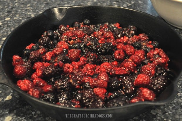 Berries (for cobbler) are placed into cast iron skillet.