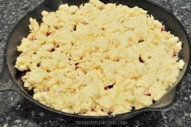 Dough is pinched off and covers the entire surface of the fruit for cobbler.