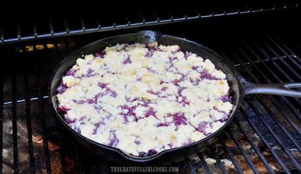 Berry cobbler in cast iron skillet is cooked outside on a Traeger grill