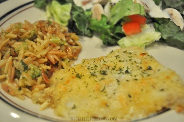 Baked cod with Parmesan crust is served with salad and rice pilaf