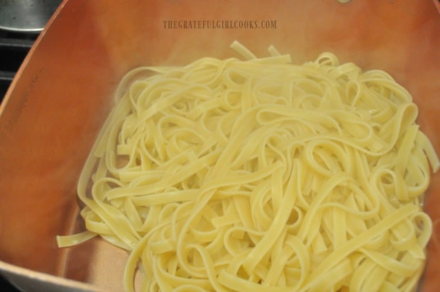 Cooked pasta is drained, then placed back into pan.