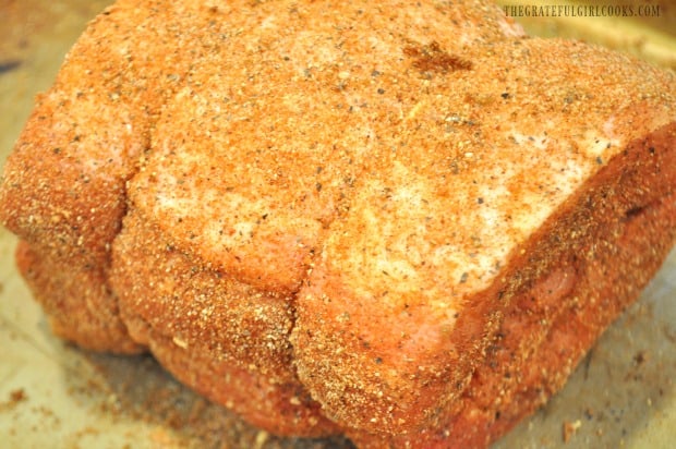 Pork loin roast is covered with dry spice rub before smoking meat on grill