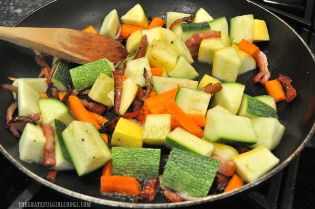 Summer squash and carrots are added to bacon sauté.