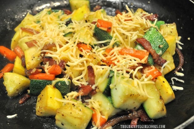 Grated cheddar cheese is added to the top of the summer squash.