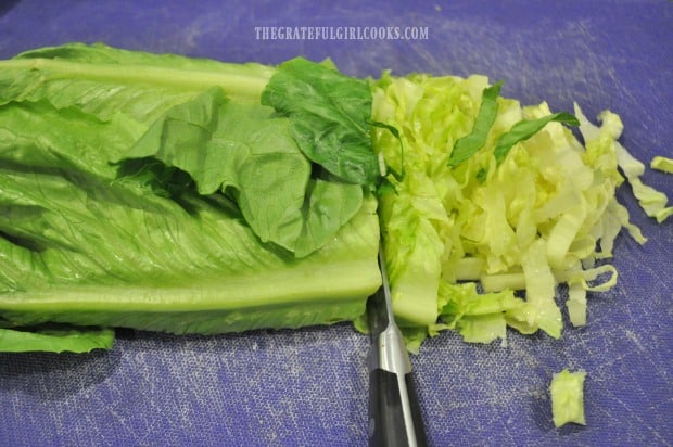 Slicing romaine lettuce for chicken caesar salad.