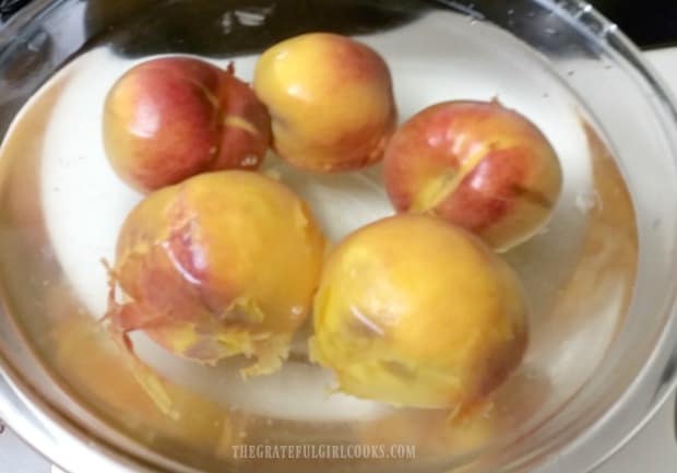 Peaches placed in ice water to help remove peel.
