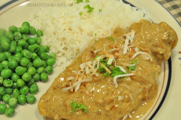 Coconut Milk Braised Chicken is served with rice and peas.