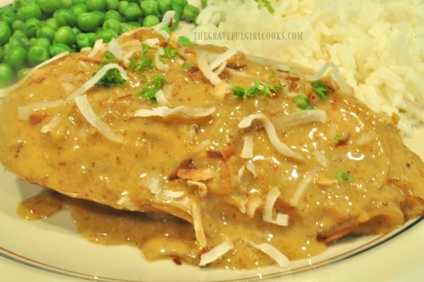 Coconut Milk Braised Chicken is garnished with parsley and toasted coconut for serving.