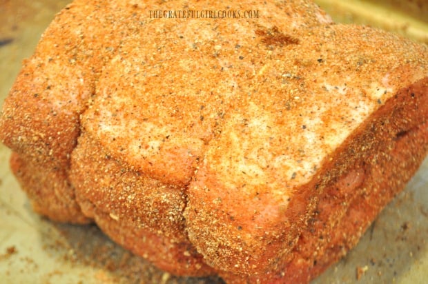 Pork loin roast with dry rub spice mix applied to surface of meat.
