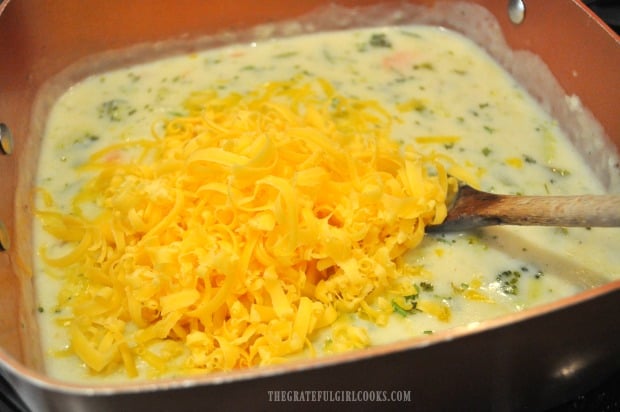 Grated cheddar cheese is added to vegetable chowder.