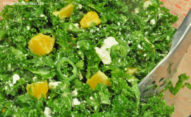 The kale orange salad is tossed with the salad dressing before serving.