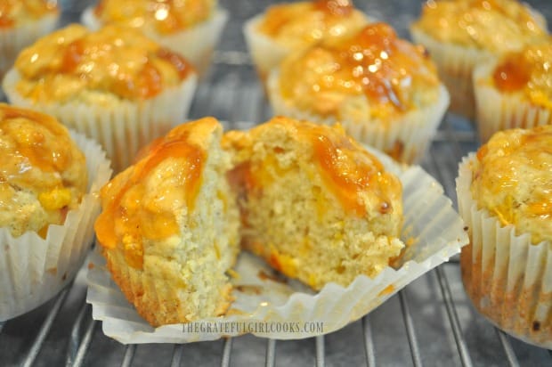 An inside look at a cut open peach jam muffin.