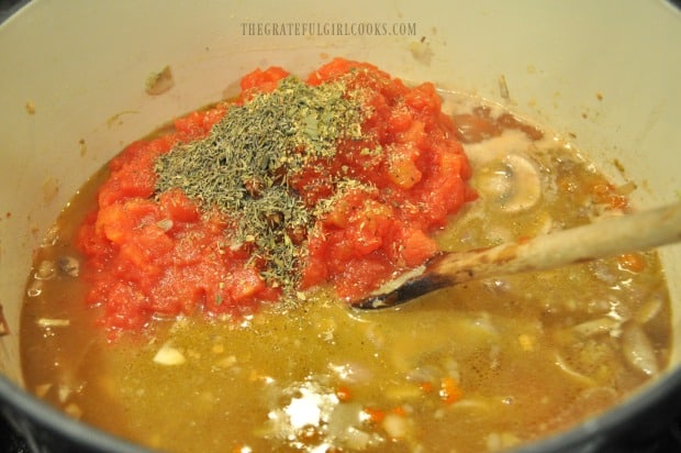 Canned tomatoes and spices are added to make ragu sauce.