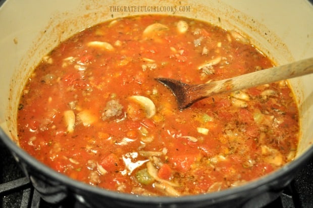 Sausage mushroom ragu sauce is cooking in large pot.