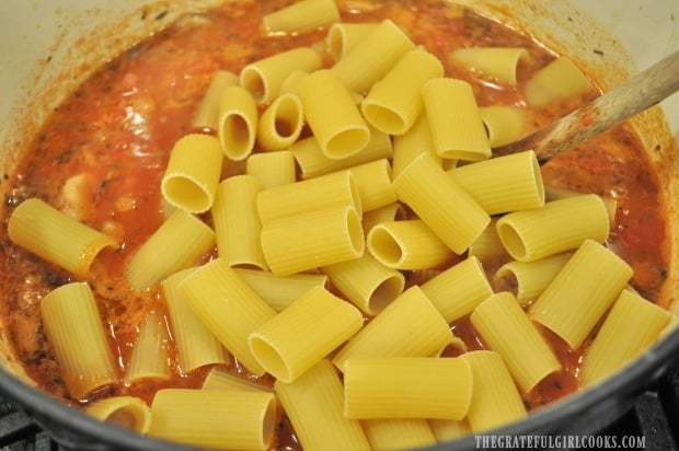 Rigatoni pasta is added to sausage musroom ragu sauce.