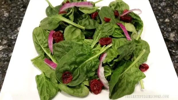 Baby spinach red onion and dried cranberries on salad.