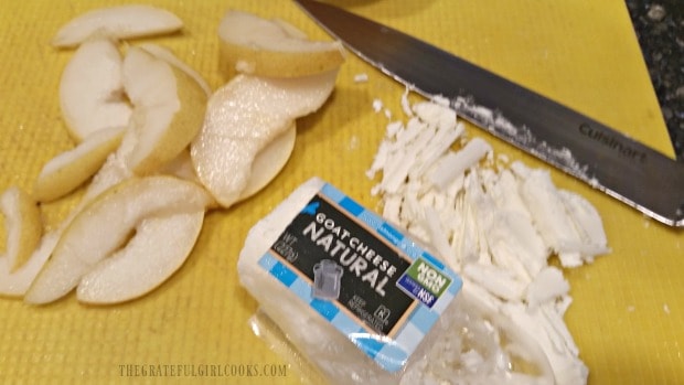 Ripe pear is sliced and goat cheese prepared for salad.