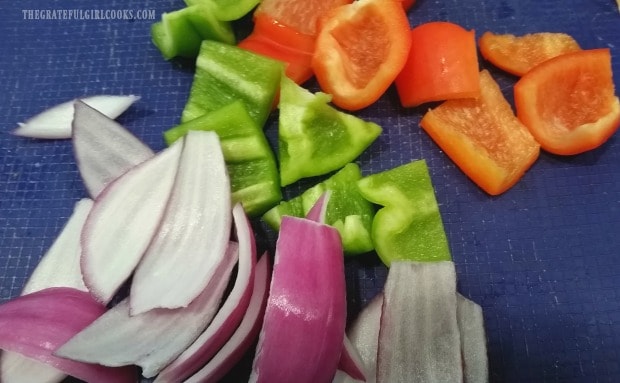 Purple onion, red and green bell peppers are cut for kabobs