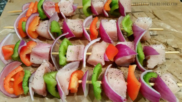 Swordfish and vegetables are threaded onto skewers for kabobs.