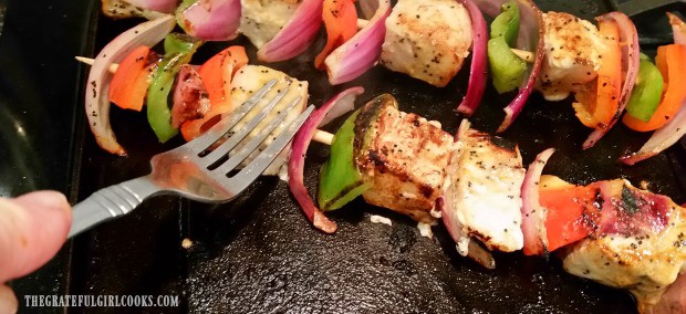 Pressing down on kabobs with fork to ensure all sides brown.