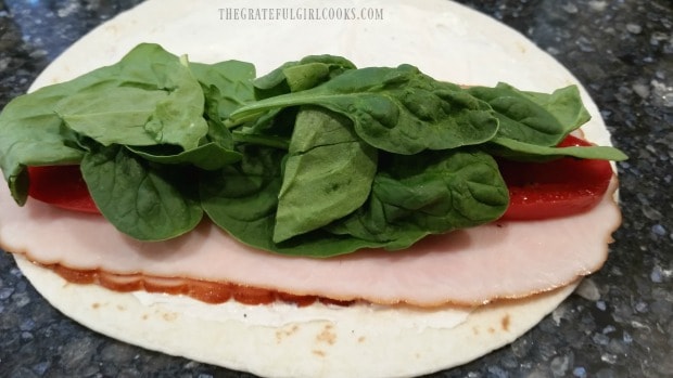 Baby spinach leaves are added to turkey ranch rollups.