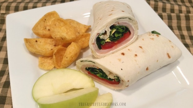 Turkey ranch rollups are cut in half, and are served with chips and apples.