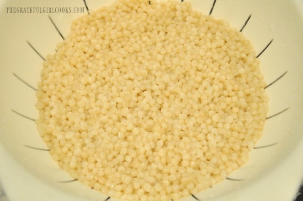 After pearl couscous is cooked, it is drained before adding to lemon herb salad.