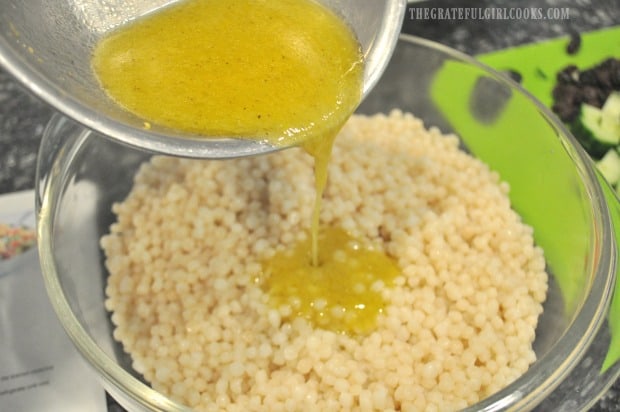 Lemon herb salad dressing is poured over warm cooked couscous.