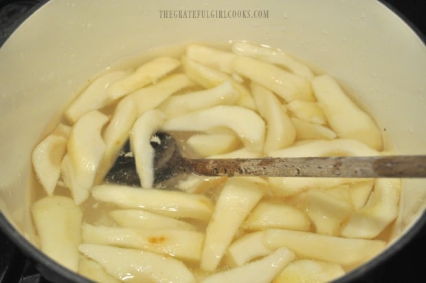 Peach slices are heated in light syrup before canning.
