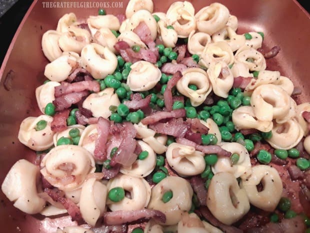 All ingredients are added to the tortellini in skillet before topping with Parmesan cheese.